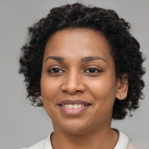 Joyful black young-adult female with short  brown hair and brown eyes