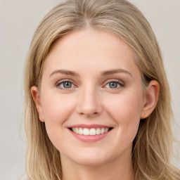 Joyful white young-adult female with long  brown hair and blue eyes