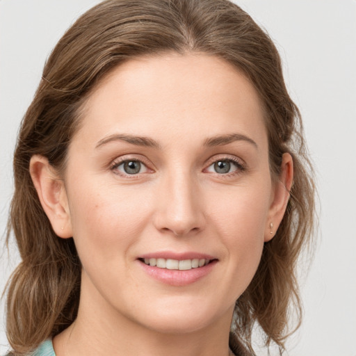 Joyful white young-adult female with medium  brown hair and grey eyes