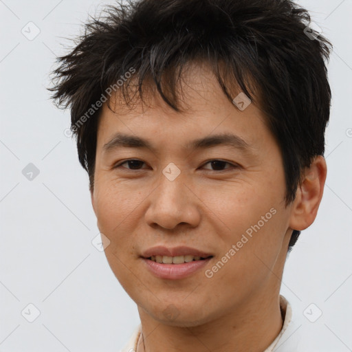 Joyful asian young-adult male with short  brown hair and brown eyes