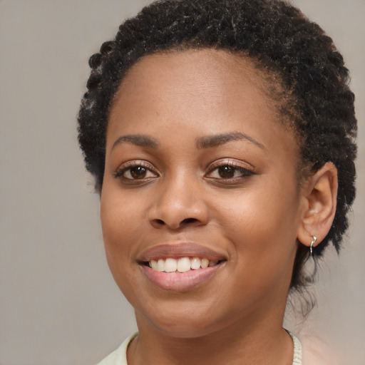 Joyful black young-adult female with short  brown hair and brown eyes