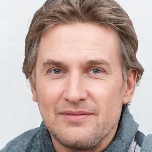 Joyful white adult male with short  brown hair and blue eyes