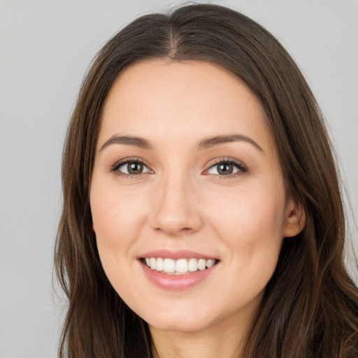 Joyful white young-adult female with long  brown hair and brown eyes