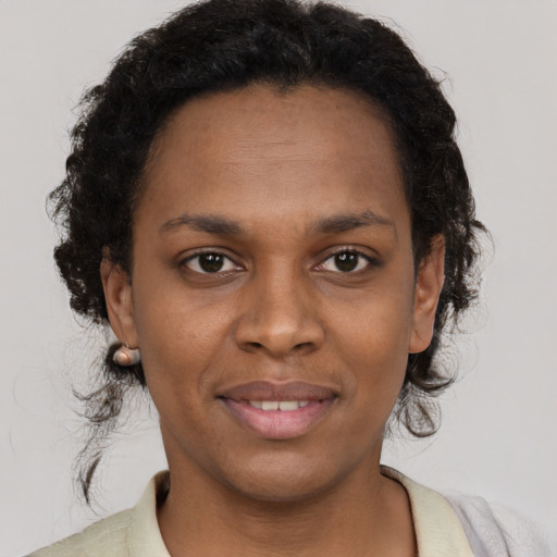 Joyful black young-adult female with short  brown hair and brown eyes