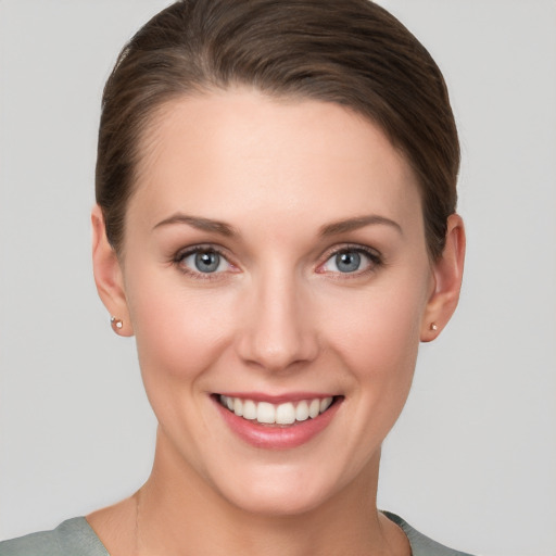 Joyful white young-adult female with short  brown hair and grey eyes