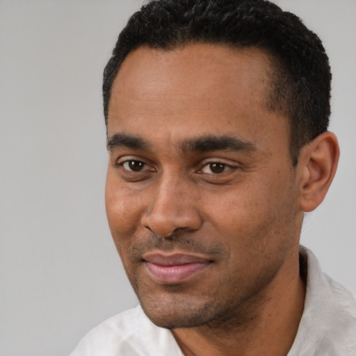 Joyful latino young-adult male with short  black hair and brown eyes
