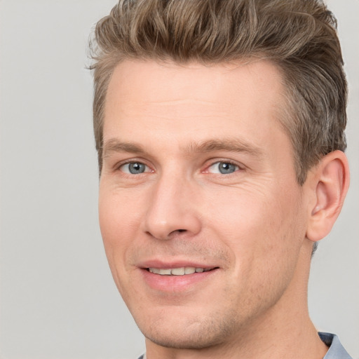 Joyful white adult male with short  brown hair and grey eyes