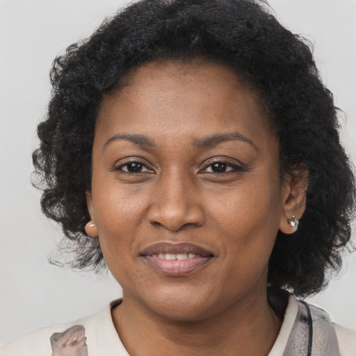 Joyful black adult female with long  brown hair and brown eyes