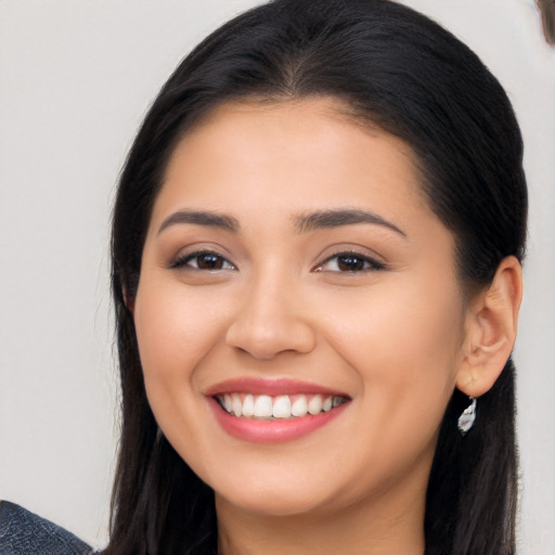 Joyful latino young-adult female with long  brown hair and brown eyes