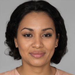 Joyful black adult female with medium  brown hair and brown eyes