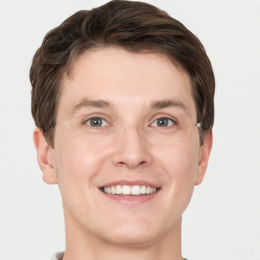 Joyful white young-adult male with short  brown hair and grey eyes