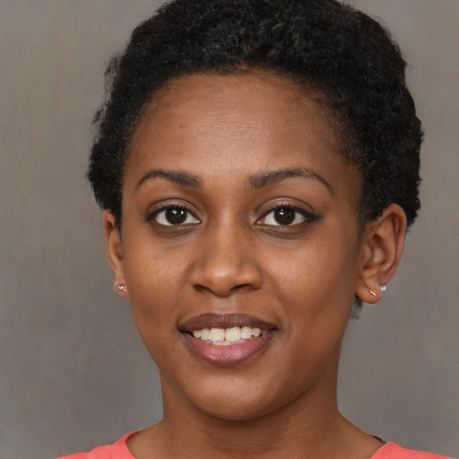 Joyful black young-adult female with short  brown hair and brown eyes