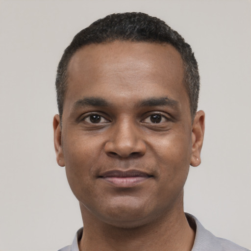 Joyful black young-adult male with short  black hair and brown eyes