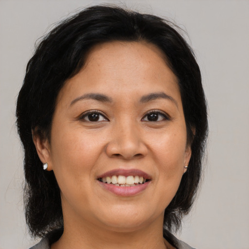 Joyful asian adult female with medium  brown hair and brown eyes