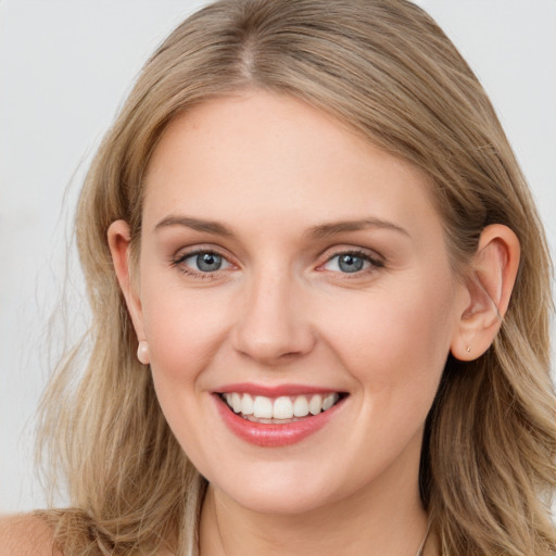 Joyful white young-adult female with long  brown hair and blue eyes