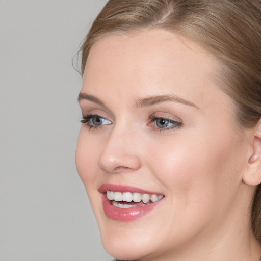 Joyful white young-adult female with long  brown hair and blue eyes