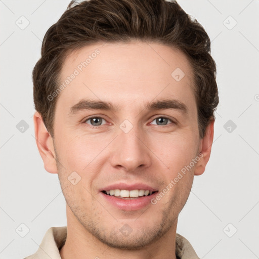 Joyful white young-adult male with short  brown hair and grey eyes