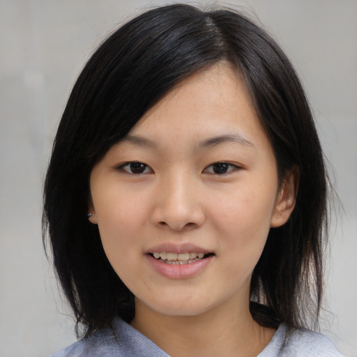 Joyful asian young-adult female with medium  black hair and brown eyes