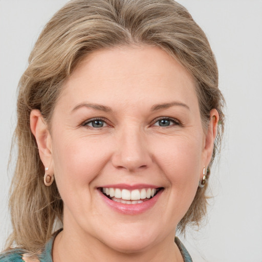 Joyful white young-adult female with medium  brown hair and blue eyes