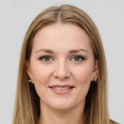 Joyful white young-adult female with long  brown hair and green eyes