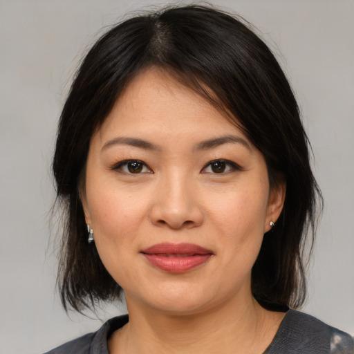 Joyful asian young-adult female with medium  brown hair and brown eyes