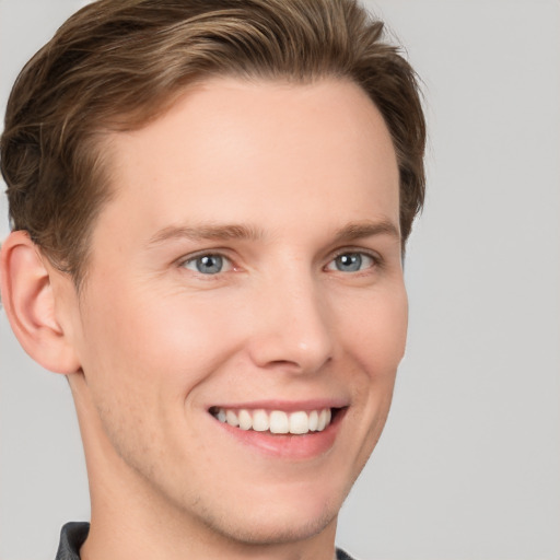 Joyful white young-adult male with short  brown hair and grey eyes