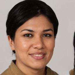 Joyful latino young-adult female with medium  brown hair and brown eyes