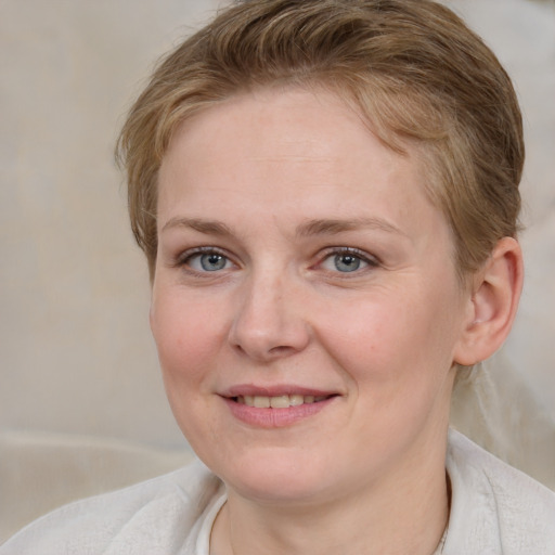 Joyful white young-adult female with medium  brown hair and blue eyes