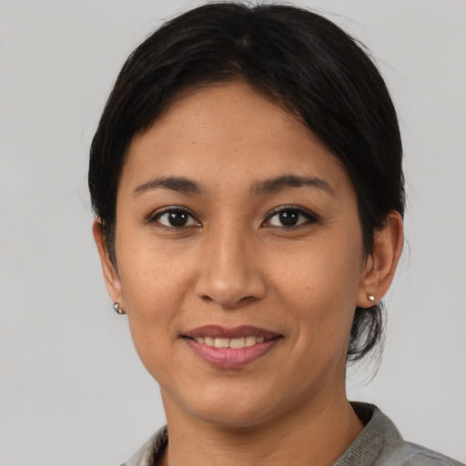 Joyful latino young-adult female with medium  brown hair and brown eyes