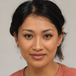 Joyful latino young-adult female with medium  brown hair and brown eyes