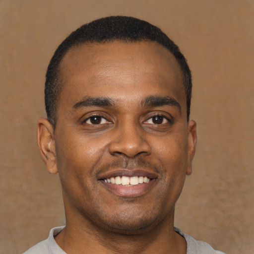 Joyful latino young-adult male with short  brown hair and brown eyes