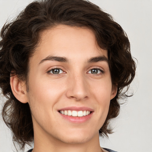 Joyful white young-adult female with medium  brown hair and green eyes