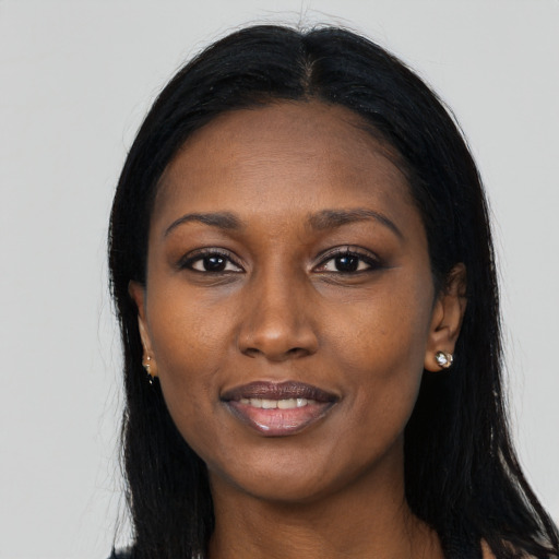 Joyful black young-adult female with long  black hair and brown eyes
