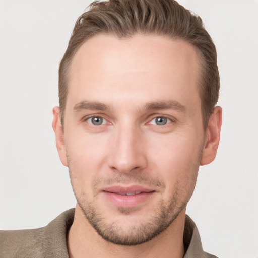 Joyful white young-adult male with short  brown hair and grey eyes