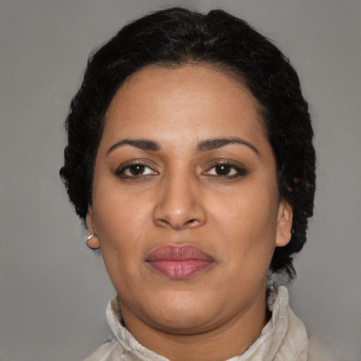 Joyful latino adult female with medium  black hair and brown eyes
