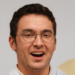 Joyful white adult male with short  brown hair and brown eyes