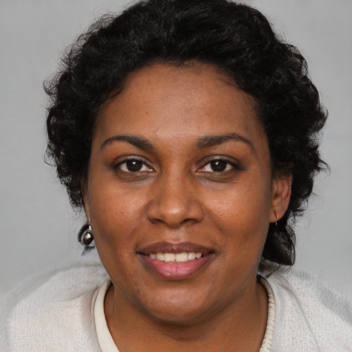 Joyful black adult female with short  brown hair and brown eyes