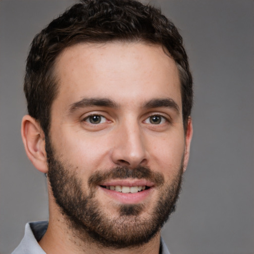 Joyful white young-adult male with short  brown hair and brown eyes