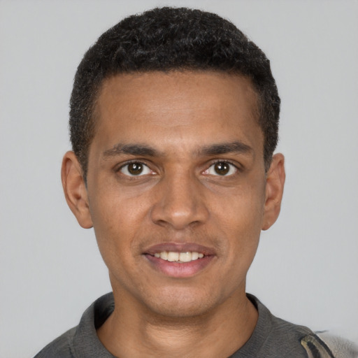 Joyful black young-adult male with short  brown hair and brown eyes