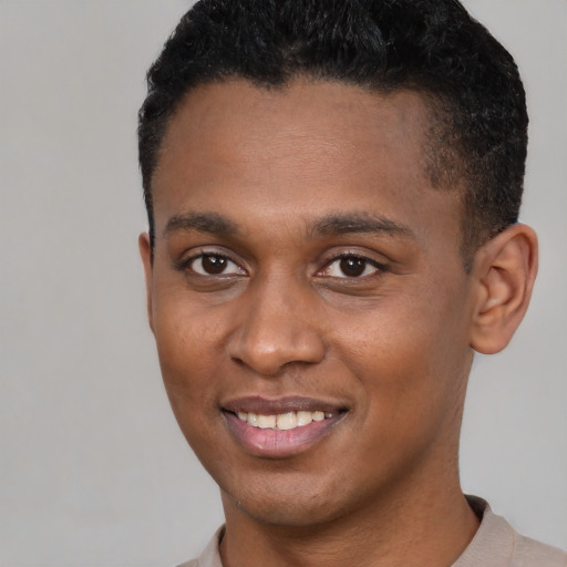 Joyful black young-adult male with short  black hair and brown eyes