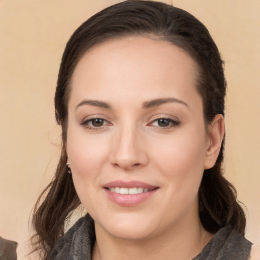 Joyful white young-adult female with long  brown hair and brown eyes