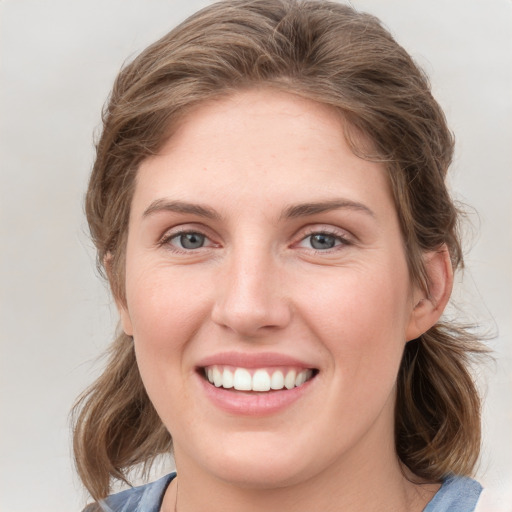 Joyful white young-adult female with medium  brown hair and blue eyes