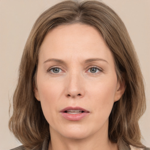 Joyful white adult female with medium  brown hair and grey eyes