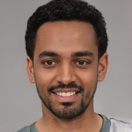 Joyful latino young-adult male with short  black hair and brown eyes