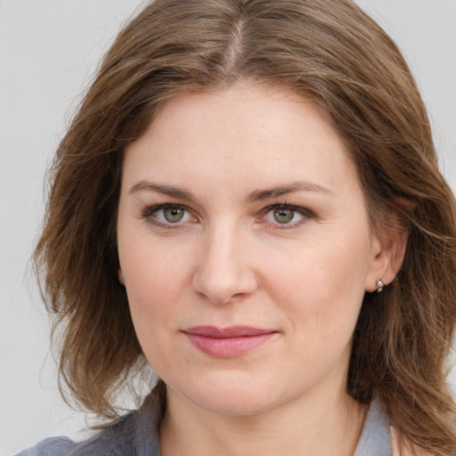 Joyful white young-adult female with medium  brown hair and green eyes