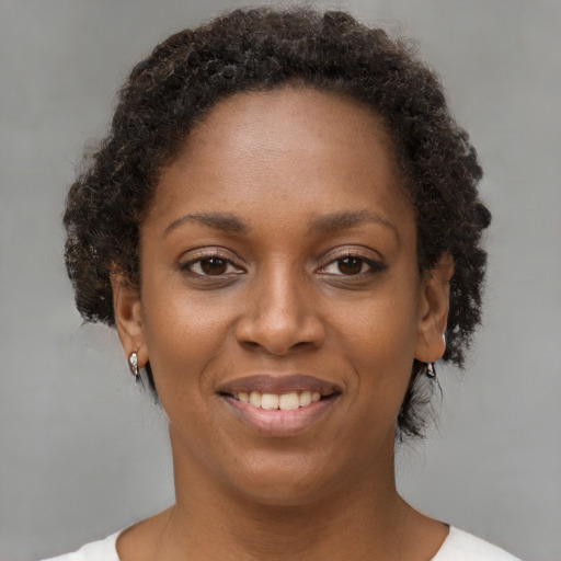 Joyful black young-adult female with short  brown hair and brown eyes