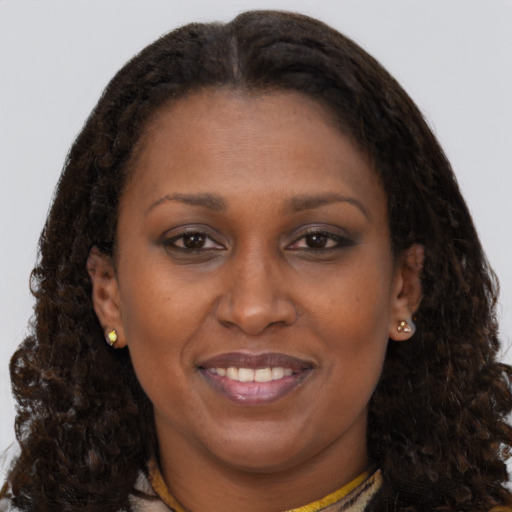 Joyful black adult female with medium  brown hair and brown eyes