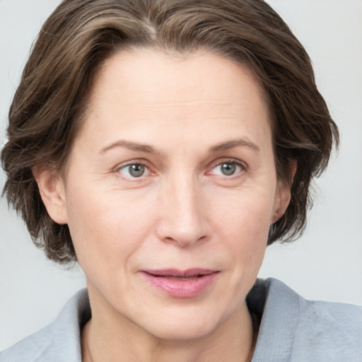 Joyful white adult female with medium  brown hair and grey eyes