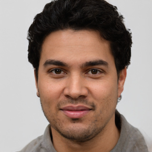 Joyful latino young-adult male with short  black hair and brown eyes