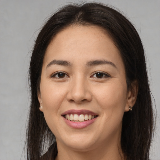 Joyful latino young-adult female with long  brown hair and brown eyes
